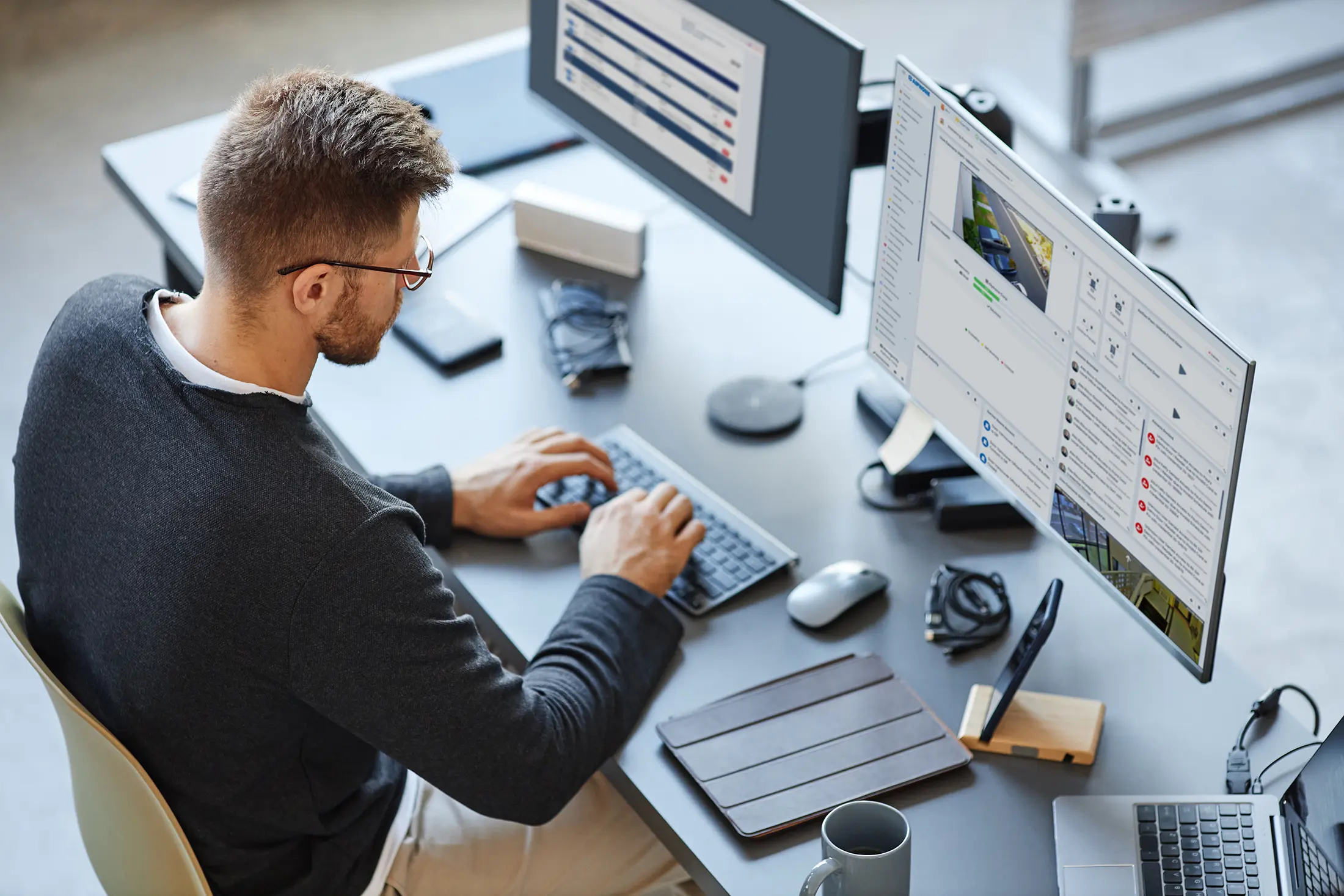 A man is working on his computer at the desk.