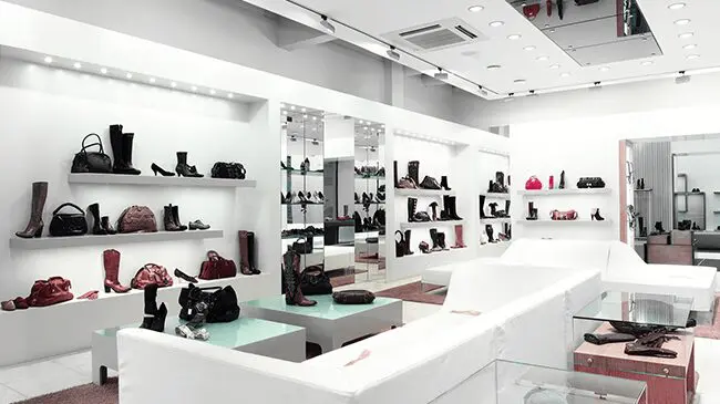 Fashion-&-specialty-stores A white store with many shoes on display.