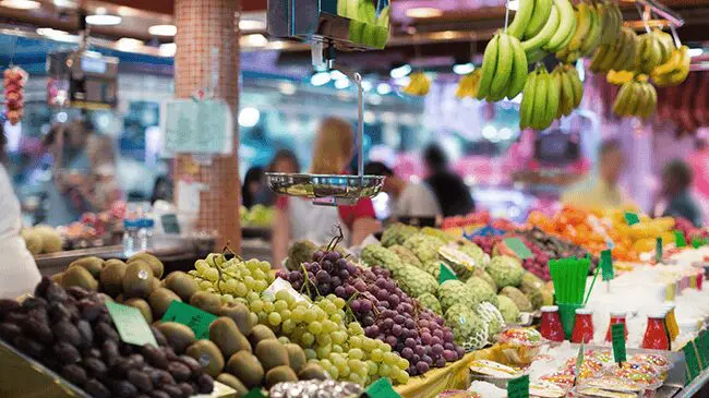Food-&-grocery-stores A market with lots of different fruits on display.
