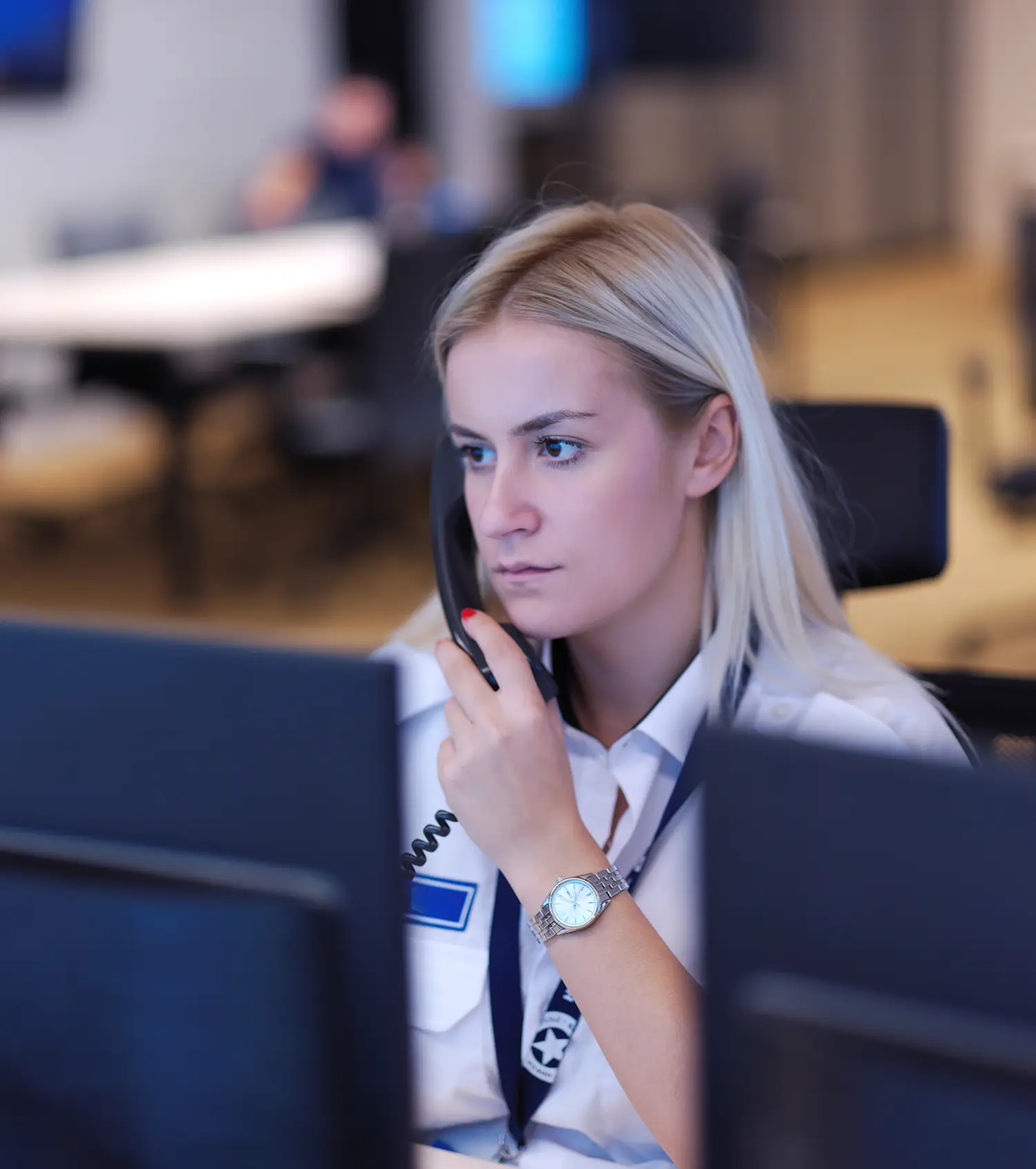 A woman sitting at her desk talking on the phone.