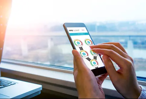 2_new_radcom-slider4d A person is holding their phone in front of the window.