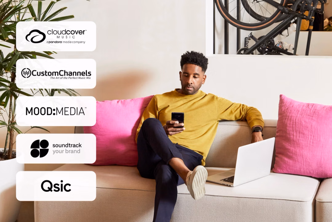 A man sitting on top of a couch looking at his phone.