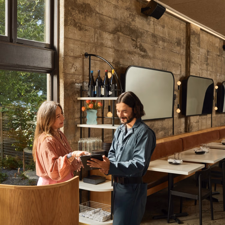 69fada15bbf5a30153e6a1b0a701e14b9e1417de-2136x2134 A man and woman are standing in front of a bar.