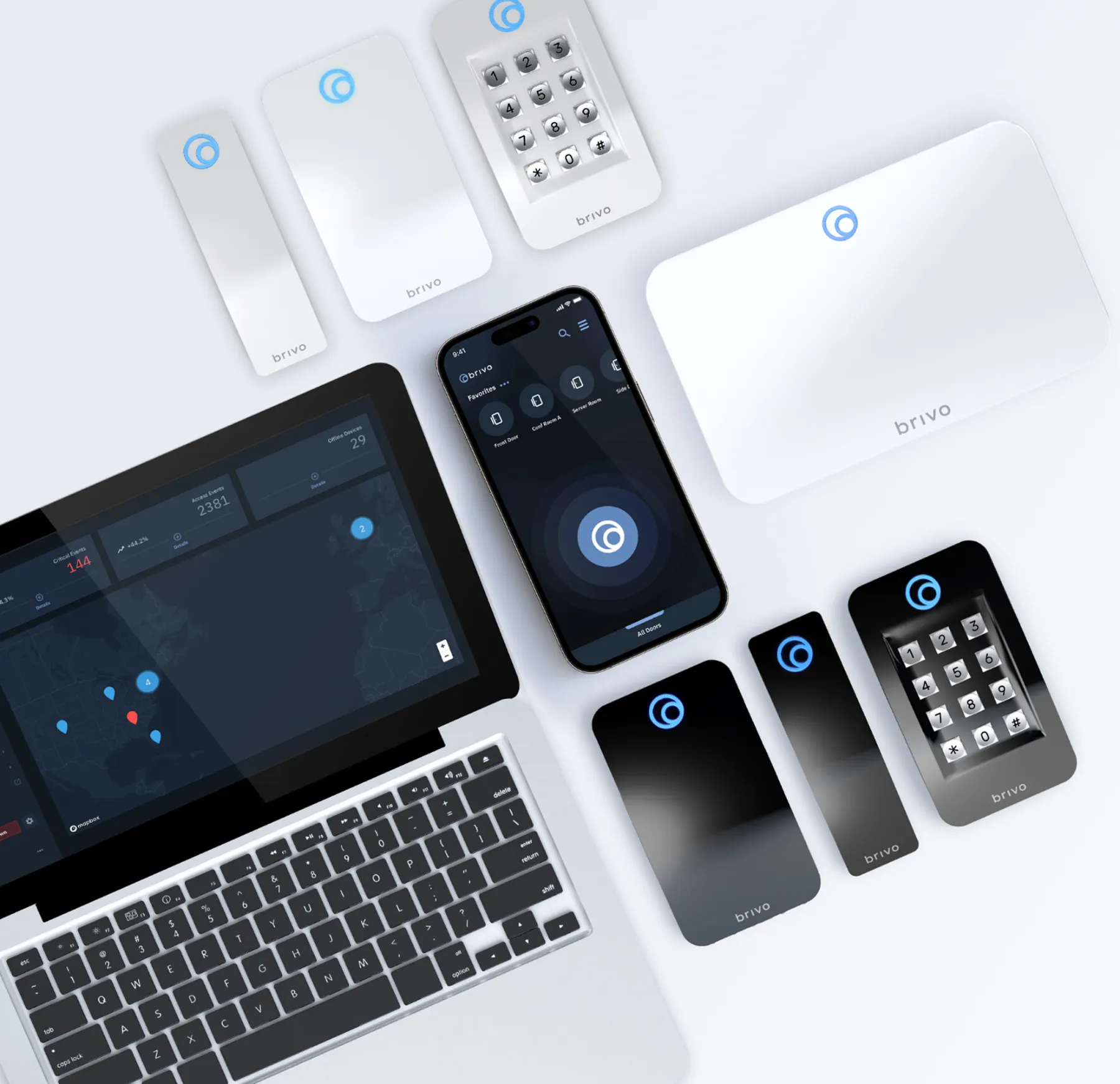 A laptop, keyboard and several different devices on the table.