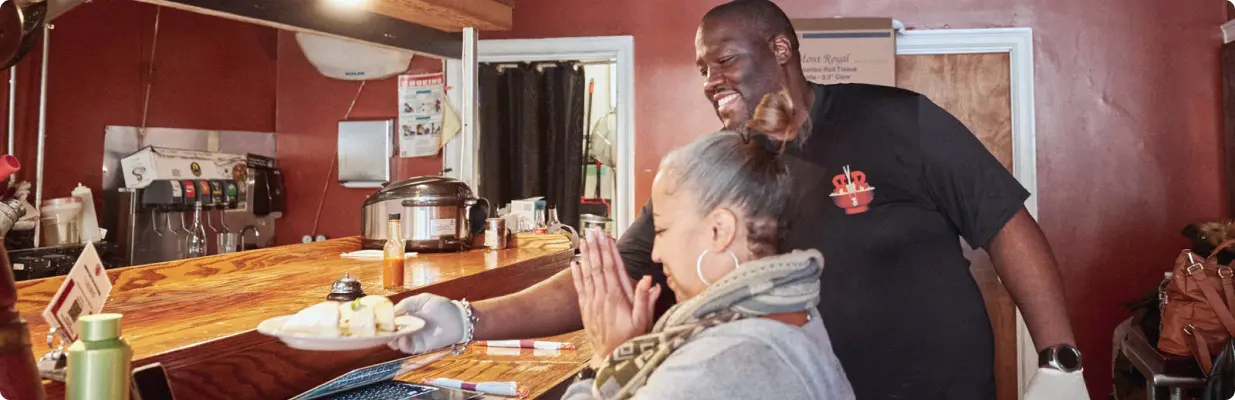 roc-n-ramen-service-lg A man and woman sitting at a table with food.
