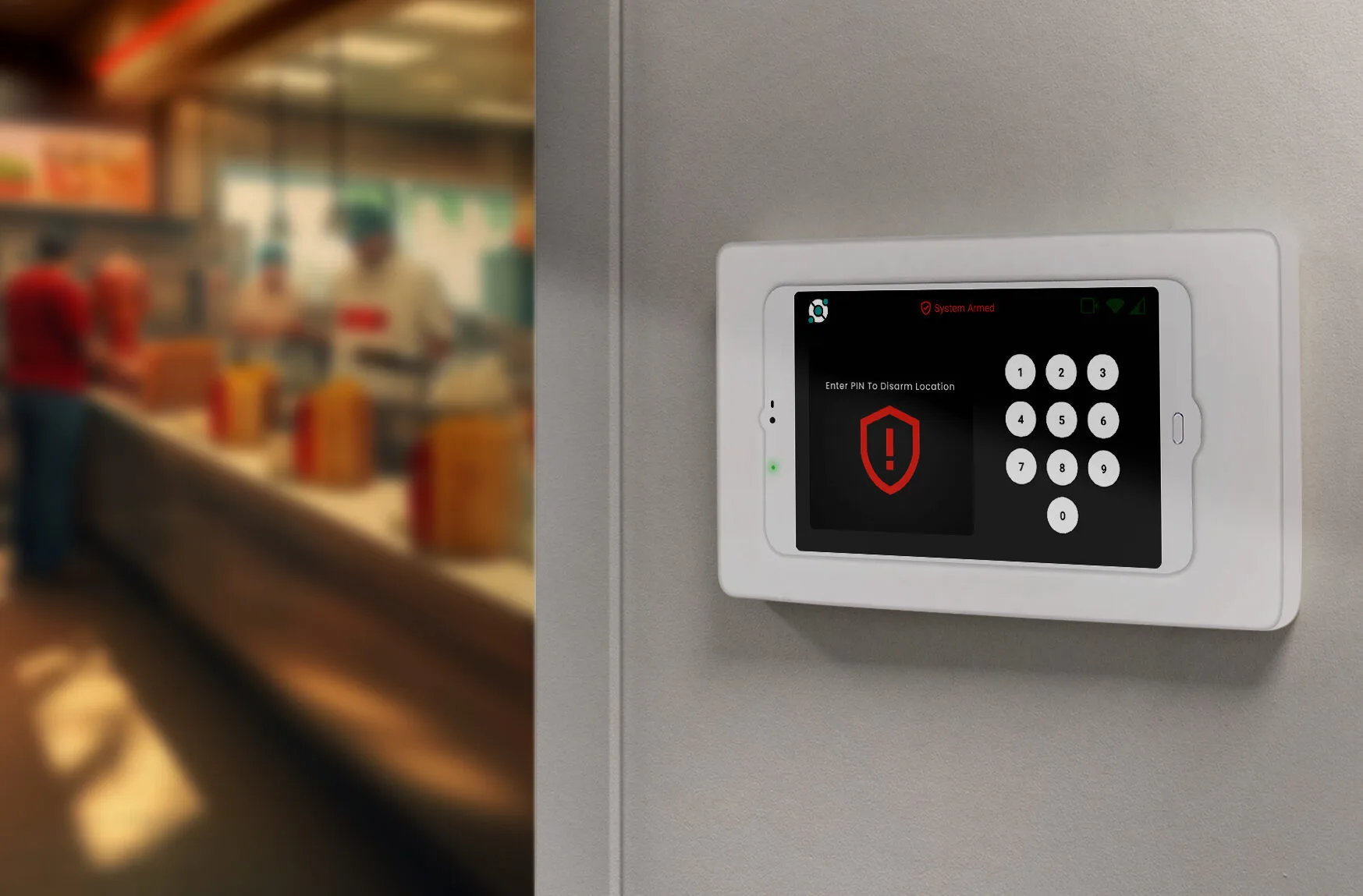 secure-your-prem-qsr A wall mounted alarm system with a red and black shield on it.