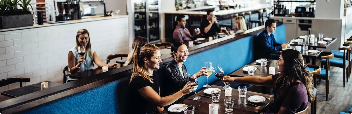 wine-bar-seating-LG A group of people sitting at a table with wine glasses.